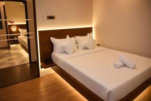 a bedroom with a white bed with a mirror at The Blue Inn Hotel in Hyderabad