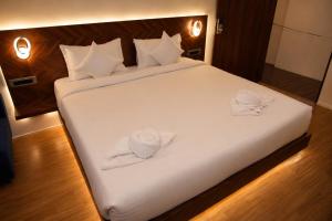 a large white bed with two towels on it at The Blue Inn Hotel in Hyderabad