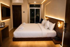 a bedroom with a large white bed with a window at The Blue Inn Hotel in Hyderabad