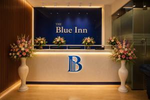 a blueim store with two vases with flowers in it at The Blue Inn Hotel in Hyderabad