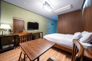 a hotel room with a bed and a desk and a table at Benikea Hotel Kakao in Seoul
