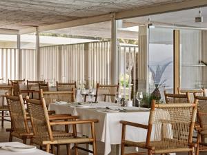 a dining room with a white table and chairs at Atlantica Nissaki Beach - Adults Only in Gimari