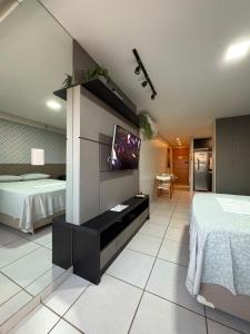 a bedroom with two beds and a tv on a wall at West Flat - BarretoStays 02 in Mossoró +10 photos