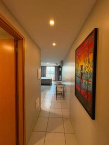 a hallway with a painting hanging on a wall at West Flat - BarretoStays 02 in Mossoró