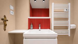 a bathroom with a white sink and a red wall at T2 Cosy - Proche Dijon -Terrasse - Parking in Pichanges +12 photos