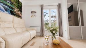 a living room with a white couch and a table at T2 Cosy - Proche Dijon -Terrasse - Parking in Pichanges