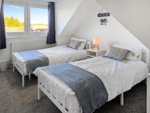 a bedroom with two beds and a window at Torr Cottage in Dalrymple +11 photos