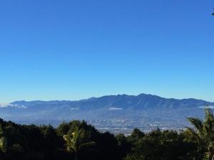 Blick auf eine Stadt mit Bergen im Hintergrund in der Unterkunft Casa Vistas del Conde in Heredia