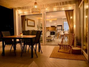 a dining room and living room with a table and chairs at Almadrava Beach in Roses