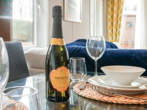 a bottle of wine sitting on a table with glasses at Marlow Lodge in Hyssington +13 photos