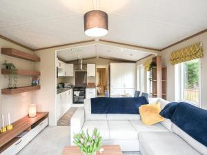 a living room with a couch and a kitchen at Marlow Lodge in Hyssington