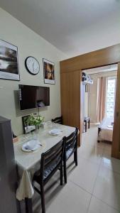 a living room with a table and a clock on the wall at Accommodating Place in Manila