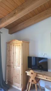 a desk with a television and a wooden cabinet at Strada Facendo in Collebrincioni