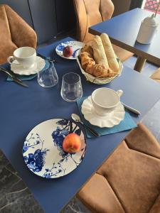 a blue table with plates of food and bread at La Villa M77 in Boitron