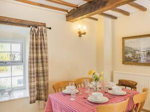 a dining room with a table and chairs and a window at Bluebell Cottage - Ukc6676 in Bettws-yn-Rhôs