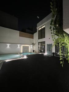 a house with a swimming pool at night at Eight House villa in Jeddah