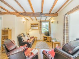 a living room with leather chairs and a tv at Primrose Cottage - Ukc6679 in Bettws-yn-Rhôs