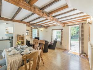 a dining room and living room with a table and chairs at Primrose Cottage - Ukc6679 in Bettws-yn-Rhôs
