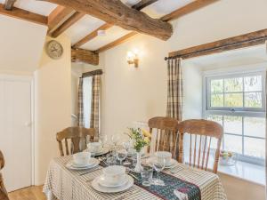 a dining room with a table and chairs and a window at Primrose Cottage - Ukc6679 in Bettws-yn-Rhôs