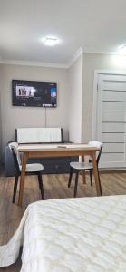 a bedroom with a desk with two chairs and a bed at Poduszka mini-hotel in Stantsiya Rokitno Volynskoye