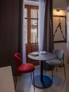 a room with a table and chairs and a window at C&O Savoia Deluxe Rooms in Cagliari