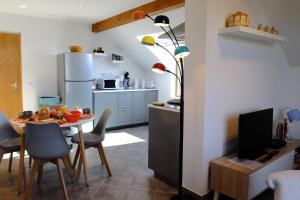 a kitchen with a table and a dining room at Appart'hôtel "Le Garage" in Saint-Bonnet-en-Champsaur