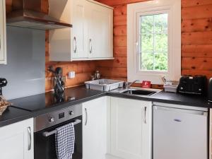 a kitchen with white cabinets and a black counter top at Barken in Trawsfynydd