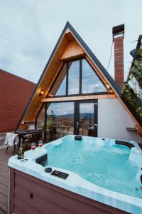 ein Whirlpool auf der Terrasse eines Hauses in der Unterkunft A-Frame Prislop,Hațeg in Silvaşu de Sus