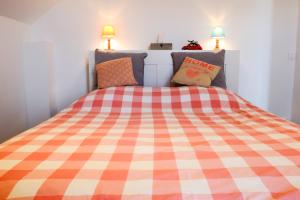 a bedroom with a bed with a checkered blanket at Appart'hôtel "Le Garage" in Saint-Bonnet-en-Champsaur