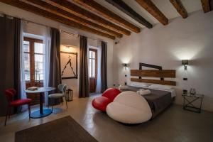 a bedroom with a large bed and a table and chairs at C&O Savoia Deluxe Rooms in Cagliari