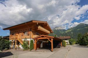 a large wooden house with a car parked in front at Haus Hochlenzerblick in Schönau am Königssee