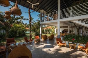 a patio with chairs and tables and a building at Panta Rei resort in Ahangama