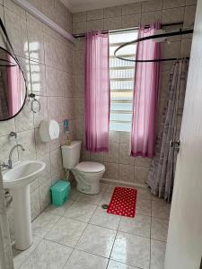 a bathroom with a toilet and a pink shower curtain at Red Monkey Hostel Barra Funda in São Paulo +34 photos