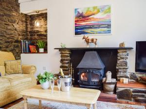 a living room with a fireplace with a horse statue on the mantle at Ty Lewis Cottage in Llanelli