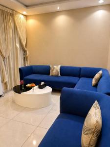 a living room with blue couches and a table at Mdmak Suites in Riyadh