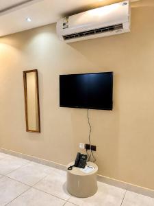 a flat screen tv on a wall with a phone at Mdmak Suites in Riyadh