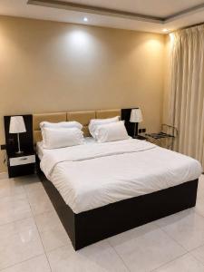 a bedroom with a large bed with white sheets and pillows at Mdmak Suites in Riyadh