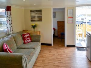 a living room with a couch and a kitchen at Ardea - Uk12695 in Stalham
