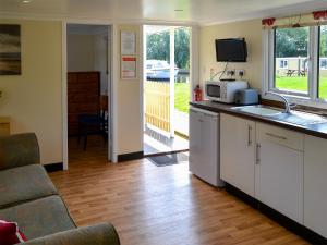 a kitchen with a sink and a microwave at Ardea - Uk12695 in Stalham