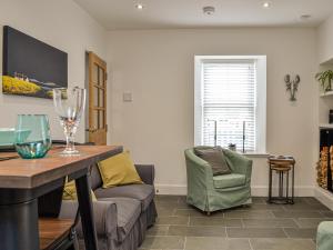 a living room with a couch and a chair at Fifie Cottage in Johnshaven