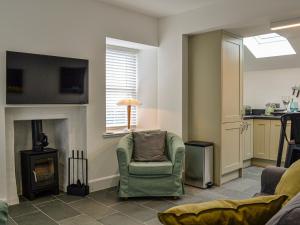a living room with a chair and a fireplace at Fifie Cottage in Johnshaven