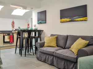a living room with a couch and a kitchen at Fifie Cottage in Johnshaven