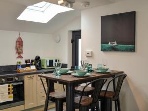 a kitchen with a wooden table with four chairs at Fifie Cottage in Johnshaven +17 photos