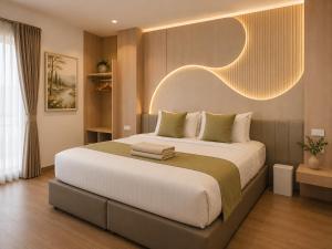 a bedroom with a large bed with a light above it at Chanaplace Lanna in Chiang Mai