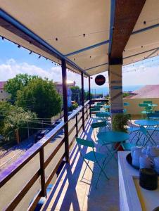 a patio with tables and chairs on a balcony at Sea View Smart Choice in Costinesti