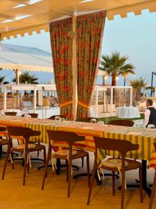 a table and chairs in a restaurant with a view at Didimos Resort in Reggio di Calabria