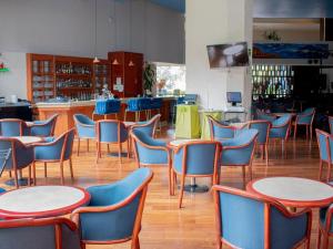 a restaurant with tables and chairs and a bar at Grand Cantalagua Hotel Morelia, BW Signature Collection in Morelia