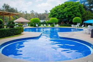 a swimming pool in a resort with chairs and umbrellas at Grand Cantalagua Hotel Morelia, BW Signature Collection in Morelia