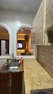 a kitchen with a sink and a living room at النسمة الهادئة - إقتصادى in Jeddah +18 photos