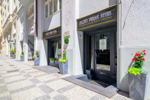 an empty street with flower pots in front of buildings at Golden Prague Rooms in Prague +50 photos